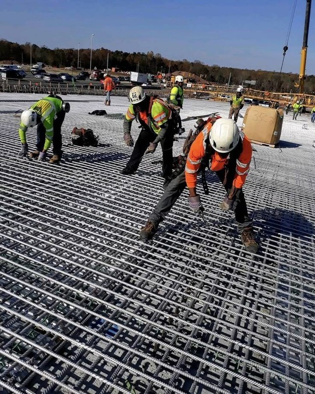 Construction workers handling steel reinforcement, from the company profile